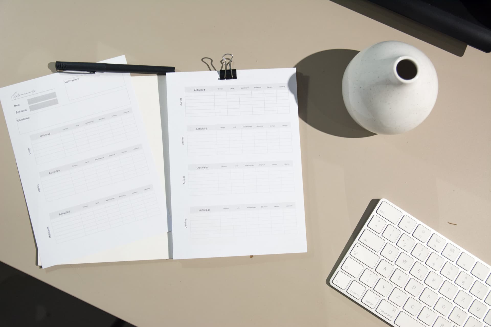 Planner pages, pen, vase, keyboard on table